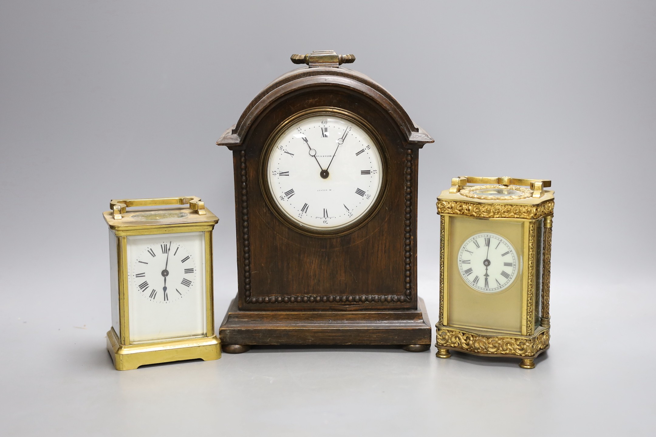 Two French brass carriage timepieces and an oak mantel clock, tallest carriage clock 12 cms high.